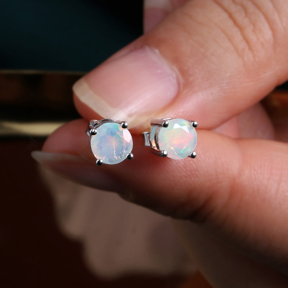 ‘Meg’ Round Faceted Opal Stud Earrings – held in fingers
