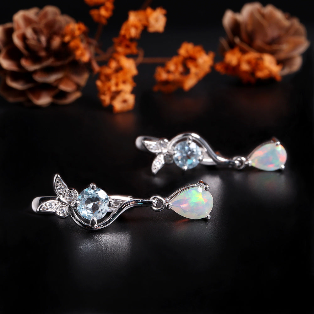 ‘Millie’ Butterfly Topaz Pear Opal Earrings – lying with flowers