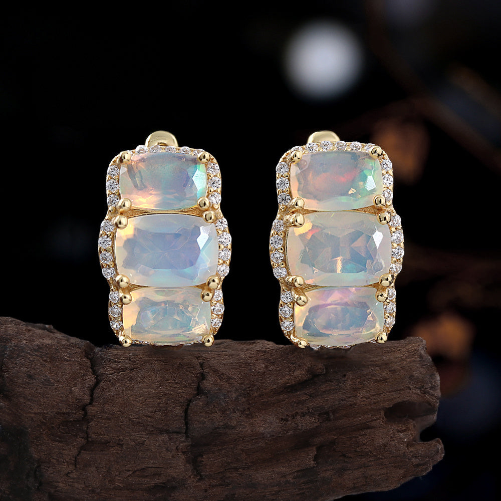 ‘Lottie’ Cushion Opal Three Stone Set – earrings on driftwood