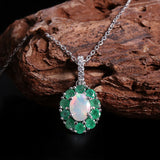 ‘Sylvie’ Oval Opal Emerald Halo Set – pendant on wood