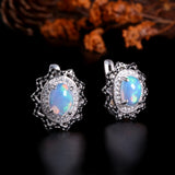 ‘Neve’ Oval Opal Starburst Halo Earrings – angle with flowers