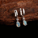 ‘Ainsley’ Pear Opal Crossover Drop Earrings – on wood