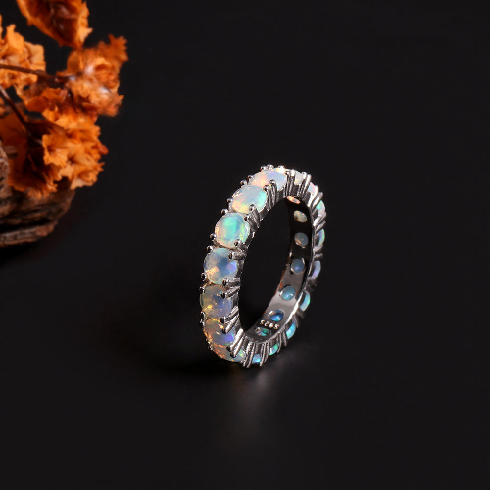 ‘June’ Round Opal Eternity Band Ring – angle with flowers