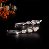 ‘Nell’ Three Opal Linear Drop Earrings – lying with flowers