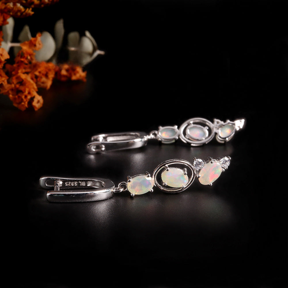 ‘Nell’ Three Opal Linear Drop Earrings – lying with flowers